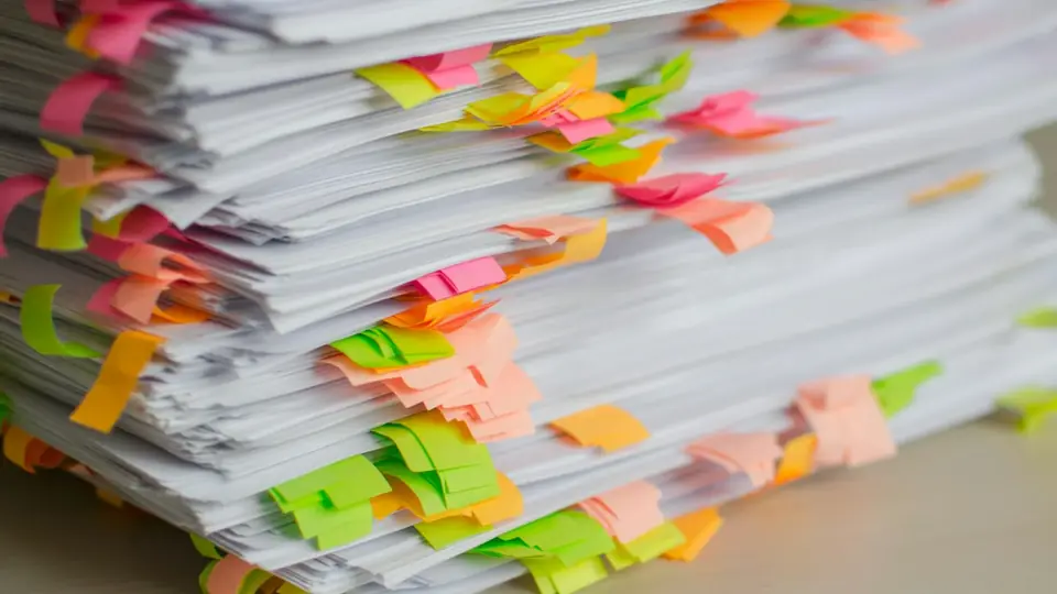 Pilha de documentos marcados com etiquetas coloridas