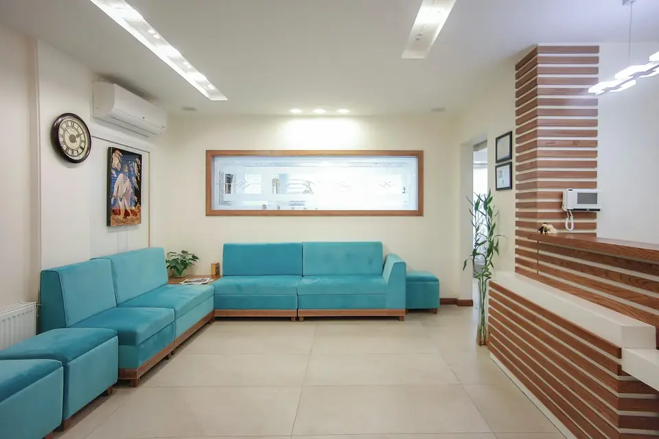 Sala de espera clara com sofás verde-água