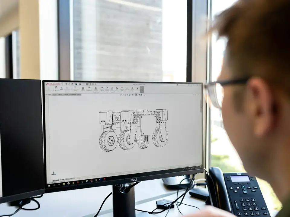 Engenheiro diante de um monitor com um desenho técnico de peça