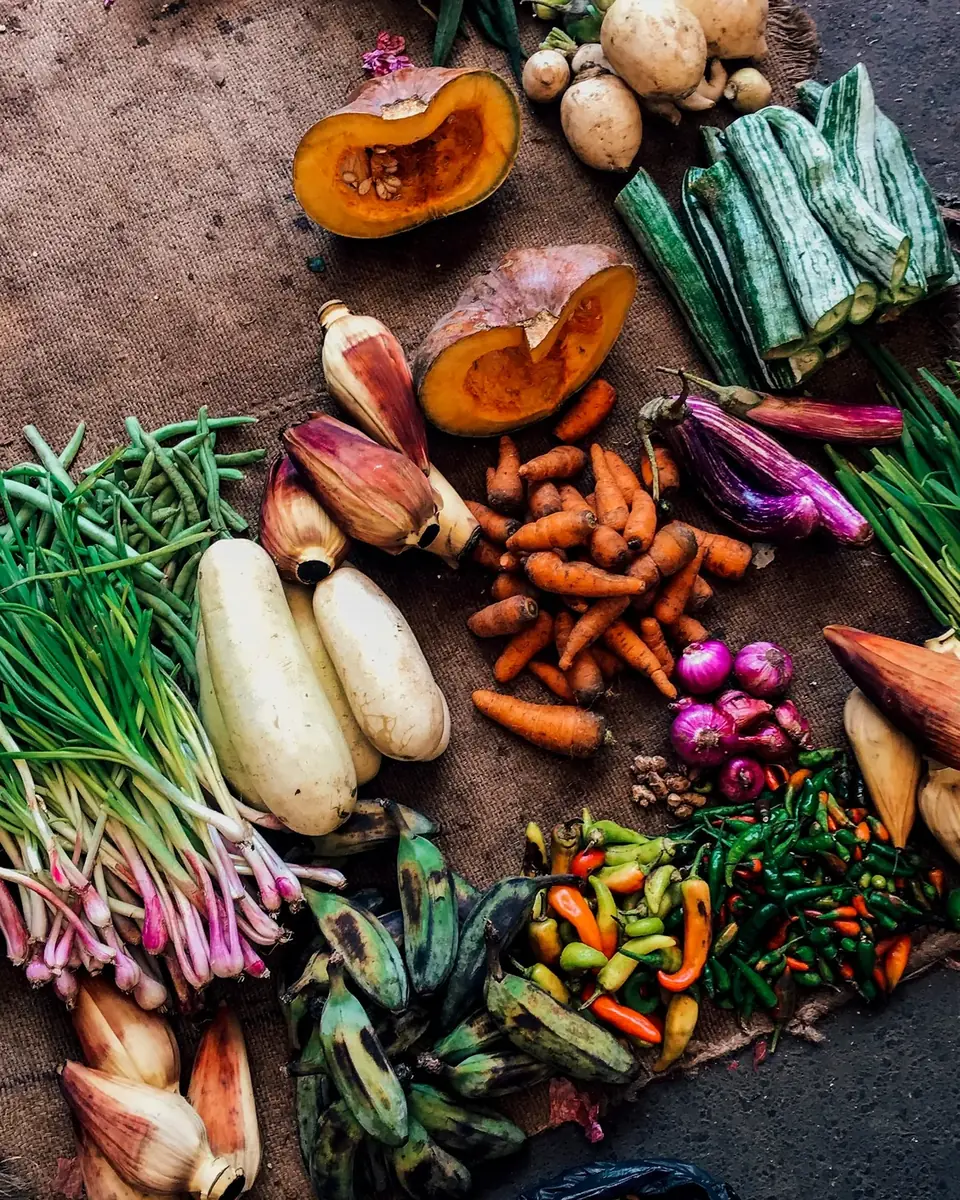 Legumes e verduras variados sobre um tecido marrom
