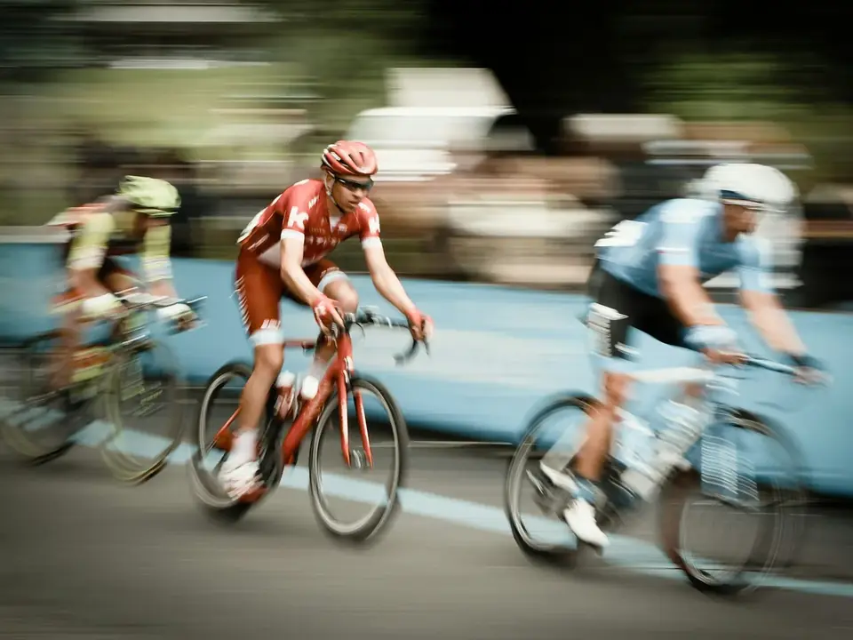 Ciclistas em velocidade numa estrada, com o fundo desfocado