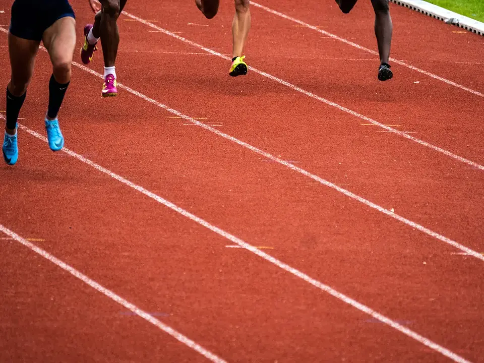Pernas de corredores em movimento na pista
