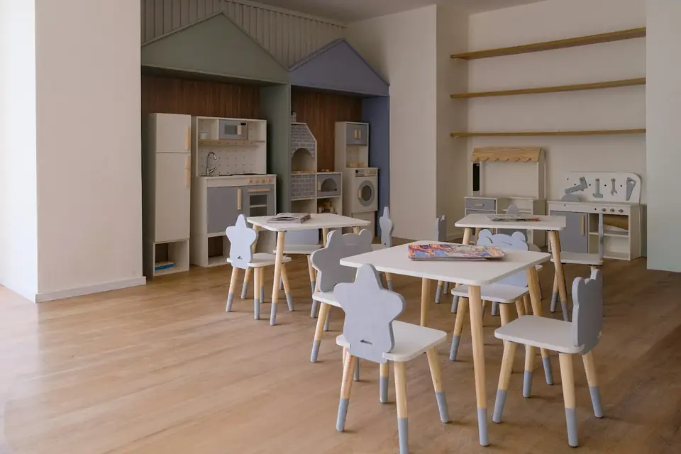 Sala de brincar com mesinhas e cadeiras infantis