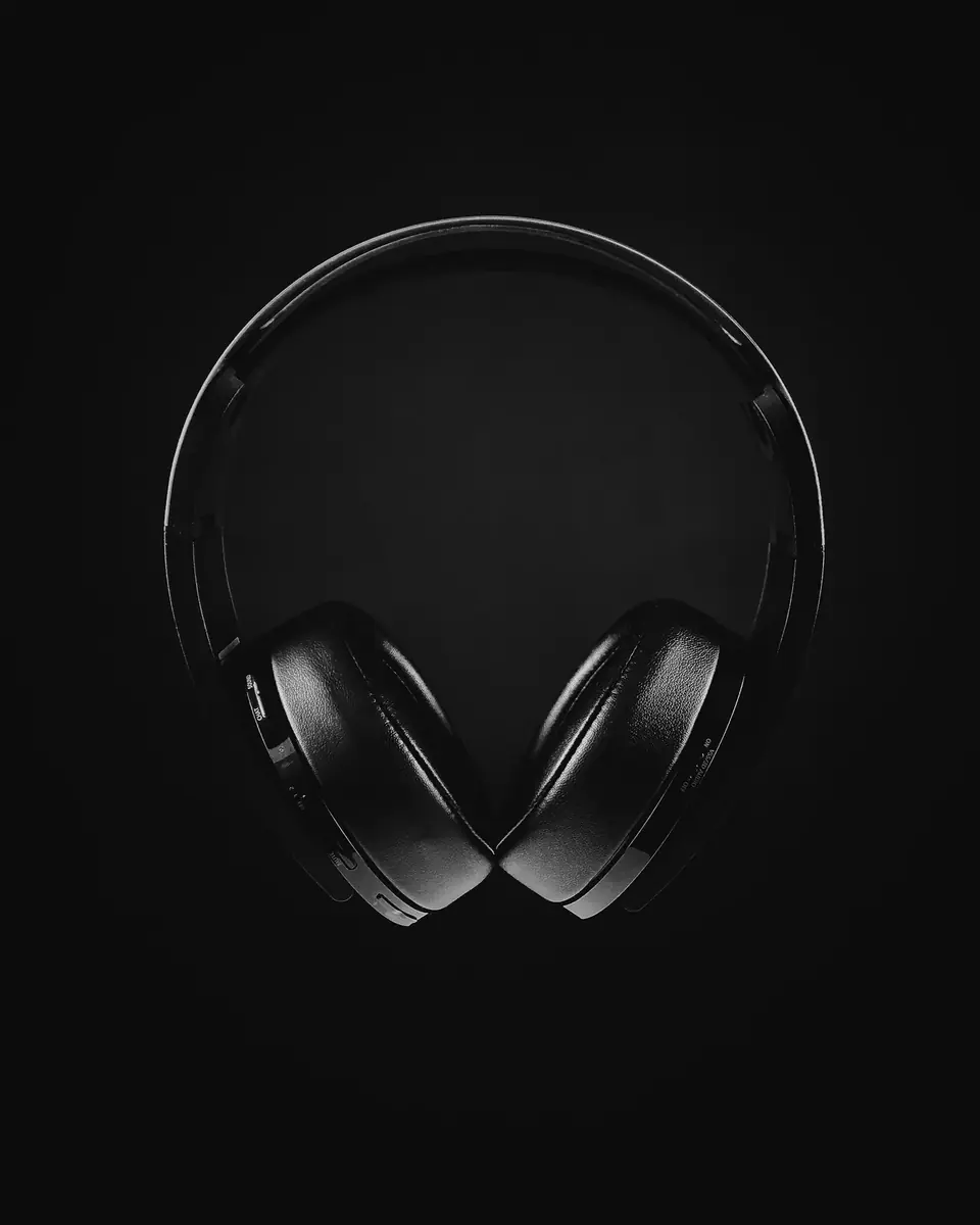 Fones de ouvido sobre fundo escuro, em preto e branco